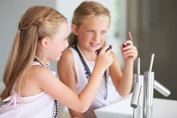 Zu verlockend, um wegzugehen - kindlicher Unfug. Freche kleine Mädchen zeichnen auf einem Spiegel mit ihren Müttern Lippenstift. — Stockfoto