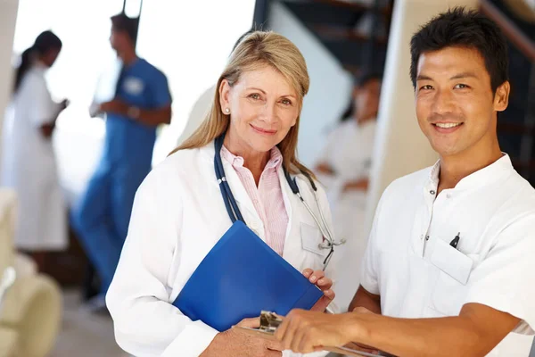 Cuidar a los profesionales de salud. Fotografía de dos profesionales médicos sonriendo a la cámara. —  Fotos de Stock