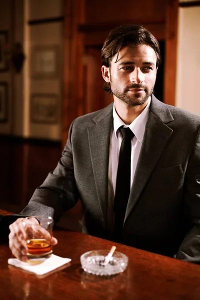 Es un cliente genial. Un joven bien vestido sentado en un bar con un trago. —  Fotos de Stock