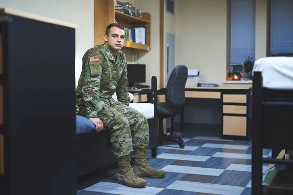 Manche nennen es Wohnheim, ich nenne es Heimat. Aufnahme eines jungen Soldaten auf seinem Bett in den Schlafsälen einer Militärakademie. — Stockfoto