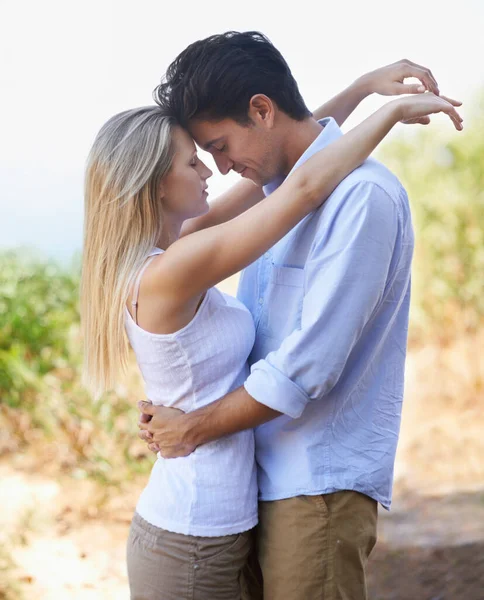 Verloren in een romantisch moment. Zijaanzicht van een gelukkig jong echtpaar omarmen liefdevol als ze staan in de natuur. — Stockfoto
