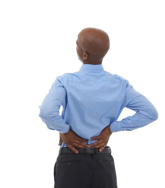 Feeling the effects of sitting all day. Rearview studio shot of an african american businessman holding his lower back in pain. — Stock Photo, Image