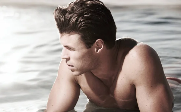 경치를 감상하는 거지. 물 속에 누워 있는 사색적 인 남자 모델. — 스톡 사진