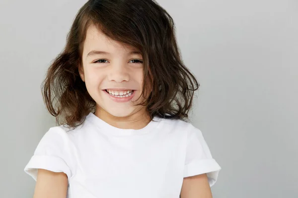 Süßes Lächeln. Porträt eines lächelnden kleinen Jungen vor grauem Hintergrund. — Stockfoto