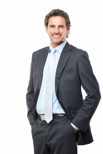 Улыбающийся бизнесмен позирует на белом фоне. Портрет красивого бизнесмена, стоящего с руками в карманах на белом фоне. — стоковое фото