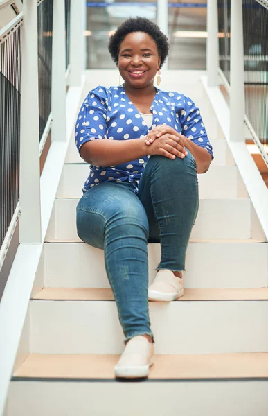 Haciendo mi camino a la cima un paso a la vez. Retrato de una joven empresaria confiada sentada en los escalones de una oficina moderna. — Foto de Stock