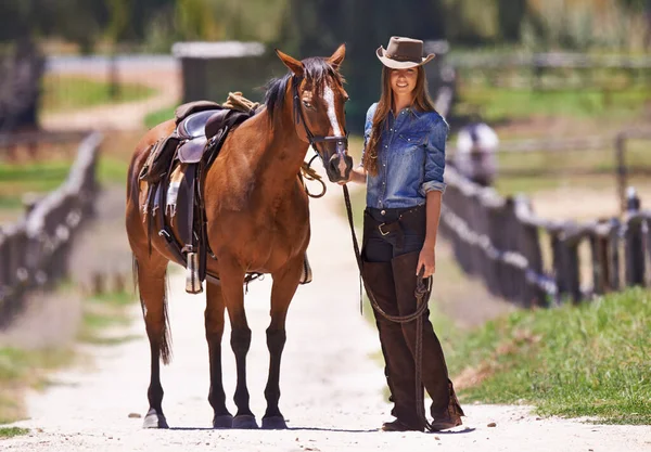 Op een dag wordt ze kampioen. Schot van een koeienmeisje die haar paard rond een ranch leidt.. — Stockfoto