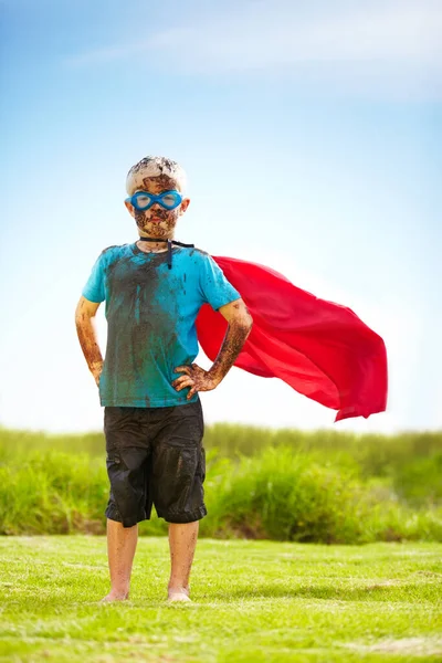 Nessuna sporcizia o fango mi rallentera '. Ritratto di un ragazzino fangoso vestito da supereroe. — Foto Stock