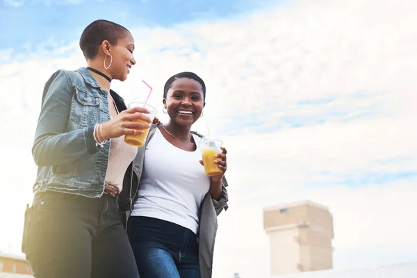 Sempre piu 'felice quando sono con te. Colpo basso di due giovani donne che camminano in città ridendo mentre tengono in mano le loro bevande fresche. — Foto Stock
