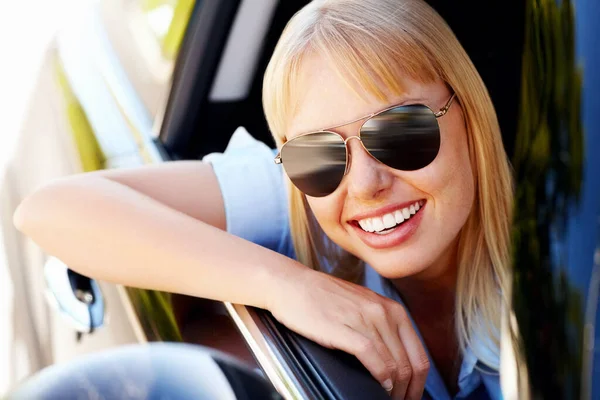 Glückliche moderne Frau sitzt am Fenster eines Autos. Nette Flugbegleiterinnen sitzen am Fenster eines Autos und lächeln. — Stockfoto