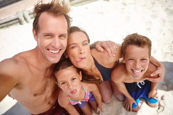 Vždycky si pamatuj tuhle dovolenou. Šťastná rodina, která si bere na pláž hloupé selfie. — Stock fotografie