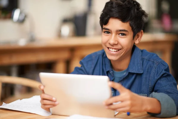 Crescendo através da educação online. Retrato de um jovem adolescente usando um tablet digital enquanto faz seus trabalhos de casa. — Fotografia de Stock