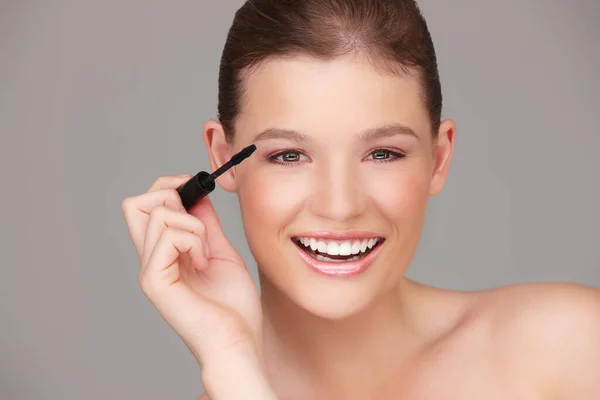 Making sure my eyes stand out. Studio portrait of a beautiful woman applying mascara. — Stock Photo, Image