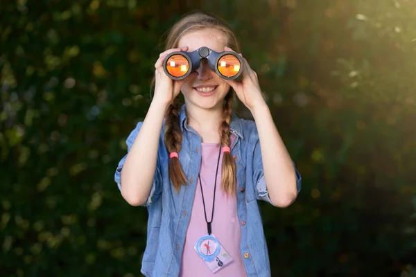 Puedo verle. Foto de una niña mirando a través de los prismáticos al aire libre. —  Fotos de Stock