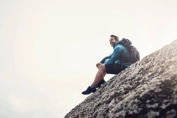 ここが正に私の心と精神が属する所です。崖から端に座っている中年の男の完全な長さのショット. — ストック写真