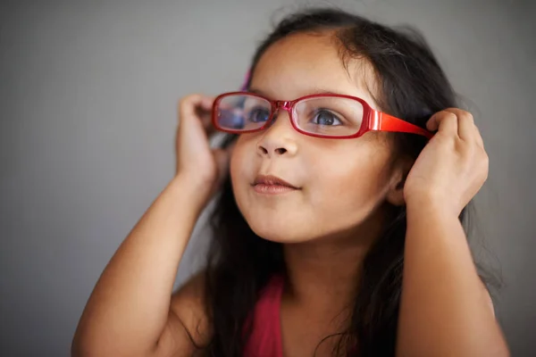 Creo que se adaptan a mí, no a ti. Shot de una linda niña pequeña probándose un par de gafas para adultos. —  Fotos de Stock