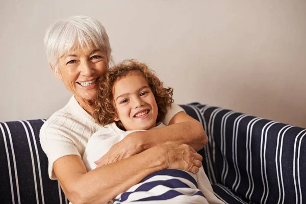 Adoro este rapaz aos bocados. Tiro de uma avó abraçando seu neto enquanto eles se sentam no sofá. — Fotografia de Stock