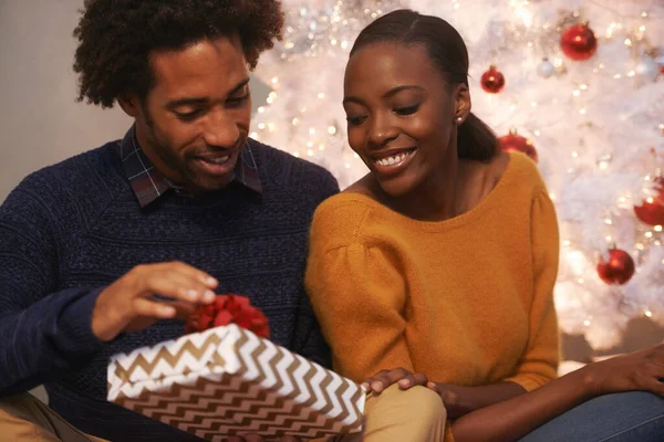 Szeretve érzem magam. Egy szerető fiatal párról, akik ajándékokat csomagolnak ki karácsonykor.. — Stock Fotó