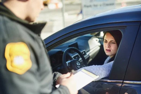 Stavi oltrepassando il limite di velocita '. Colpo di scena ritagliato di un agente del traffico maschile irriconoscibile che emette un biglietto per una civile in un posto di blocco. — Foto Stock