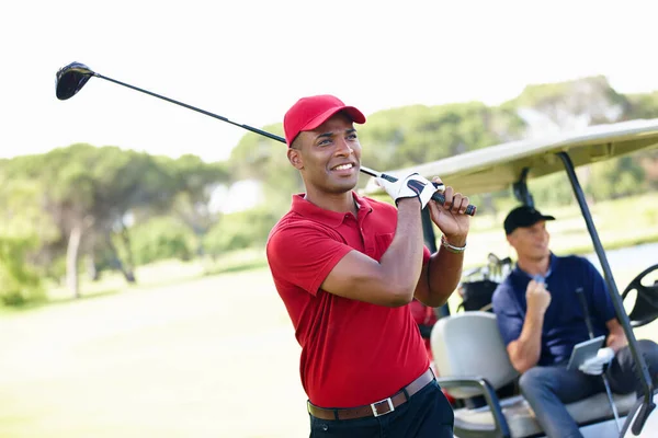 Elle était bonne. Tourné d'un jeune homme prenant un coup de feu tandis que son ami le félicite de la voiturette de golf en arrière-plan. — Photo