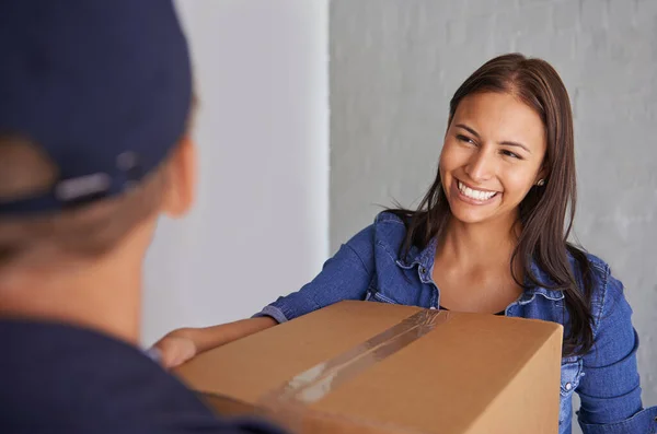Zawsze znajdź godną zaufania firmę przeprowadzkową. Piękna młoda kobieta uśmiecha się do kamery, gdy zabiera pudełko od przeprowadzki. — Zdjęcie stockowe