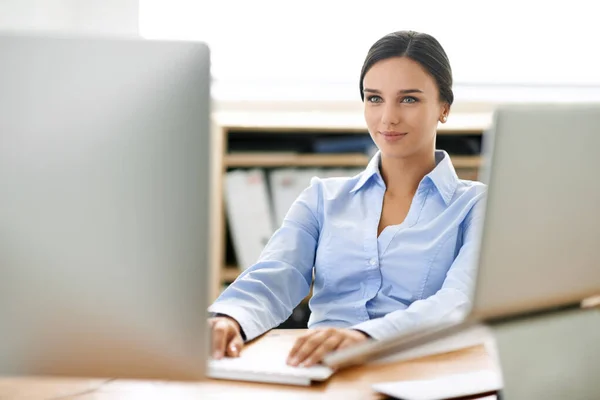 Never too far. Shot of a young office professional working at a computer. Stock Photo