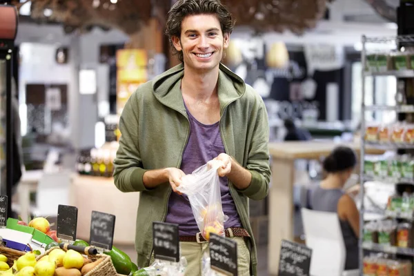 Ich muss mich mit etwas Obst eindecken. Ein junger Mann im Laden kauft Obst. — Stockfoto