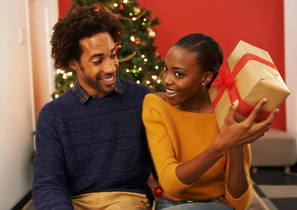 Lo que sea. Fotografía de una joven mujer sosteniendo su regalo de Navidad mientras estaba sentada junto a su novio. —  Fotos de Stock