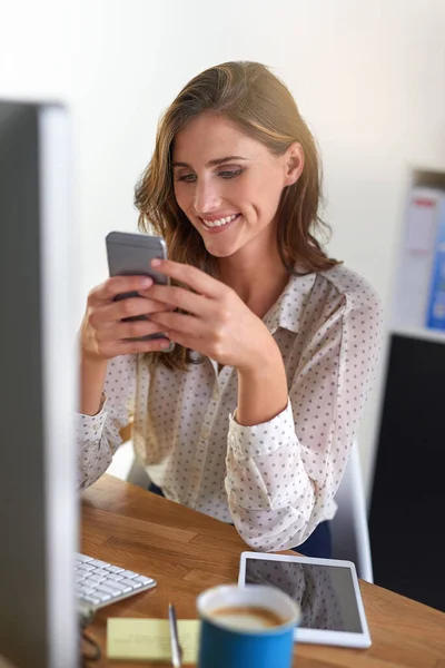 Liczne kontakty biurowe. Ujęcie młodej bizneswoman korzystającej z telefonu komórkowego w biurze. — Zdjęcie stockowe