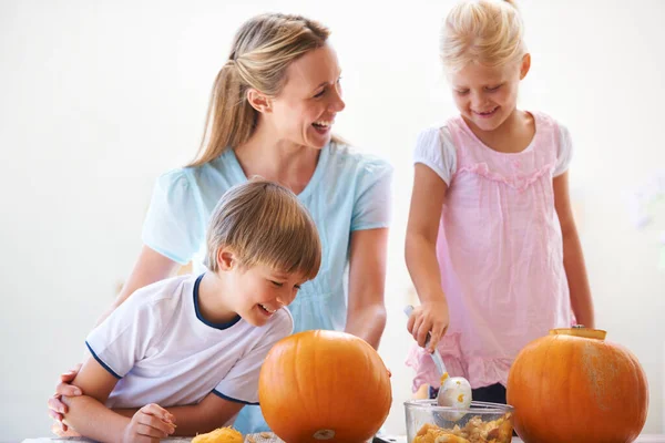 A scolpire zucche con la mamma. Una madre, suo figlio e sua figlia scavare zucche per Halloween. — Foto Stock