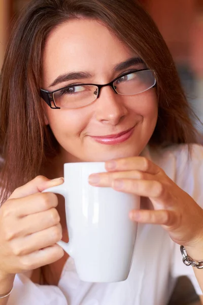 Entusiasmado para o dia que vem. Uma jovem mulher bebendo seu café com um olhar atencioso. — Fotografia de Stock