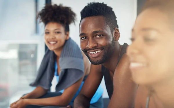 Omge dig med träningssinnade människor. Beskuren bild av tre ungdomar som sitter i gymmet efter yogaklassen. — Stockfoto