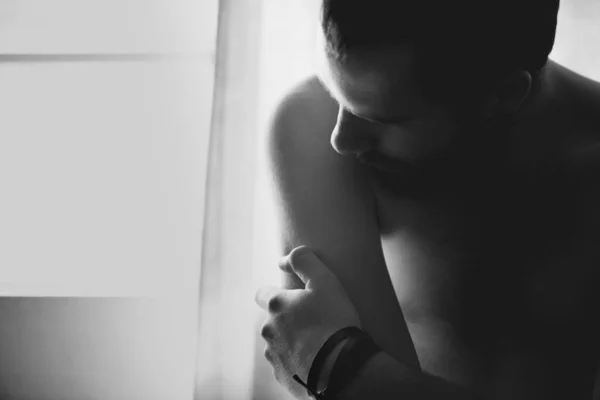 Váha osamělosti. Mladý muž zabývající se úzkostí, zatímco sedí sám ve své ložnici. — Stock fotografie