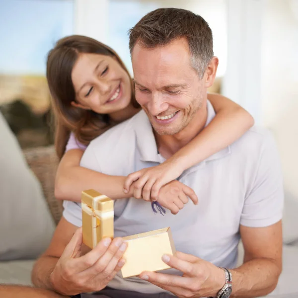 She still doesnt know that shes the greatest gift of them all. A young girl giving her dad a gift for fathers day. — Stock Photo, Image