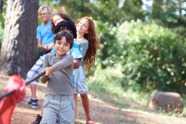 Trek aan. Kinderen spelen in het touwtrekken in het bos. — Stockfoto