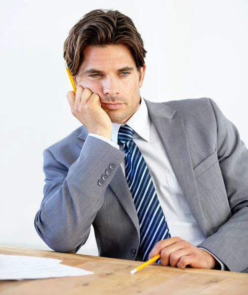 J'ai besoin d'un changement de carrière. Jeune homme d'affaires ennuyé assis à son bureau. — Photo