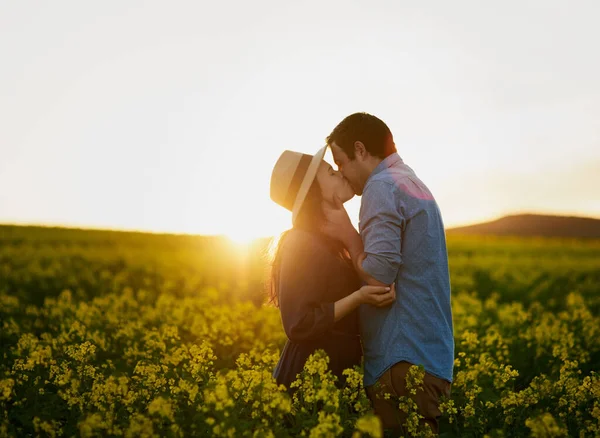 Partilhar um momento mágico juntos. Tiro de um jovem casal afetuoso compartilhando um beijo ao pôr do sol. — Fotografia de Stock