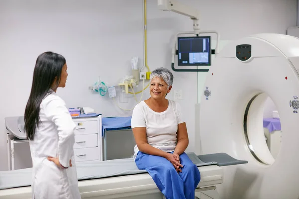 Laat me uitleggen hoe dit werkt... Foto van een oudere vrouw die eerder met een arts praatte en MRI scan. — Stockfoto