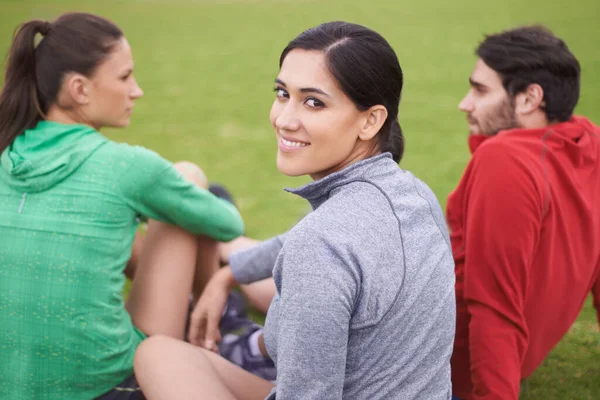 朋友和健康。穿着运动服坐在草地上的年轻人的画像. — 图库照片