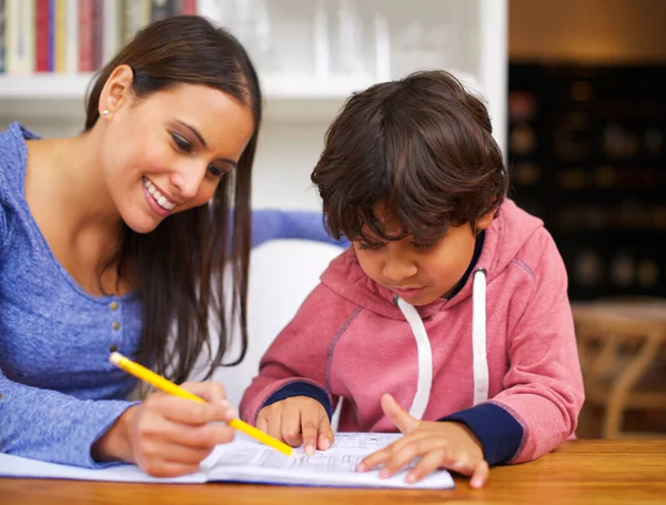 Imparare con amore. Girato di una madre che aiuta suo figlio con i compiti. — Foto Stock