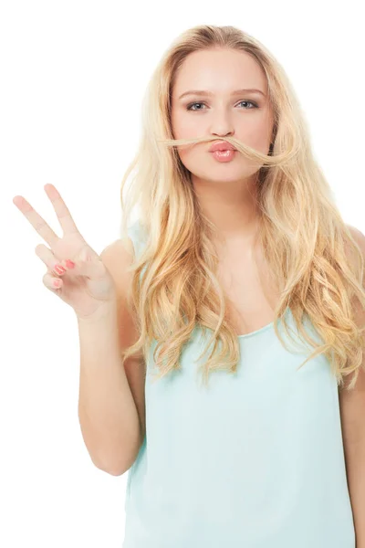 Dai una possibilita 'alla pace. Una giovane bionda stravagante che ti mostra un segno di pace con i capelli sulla bocca isolato. — Foto Stock