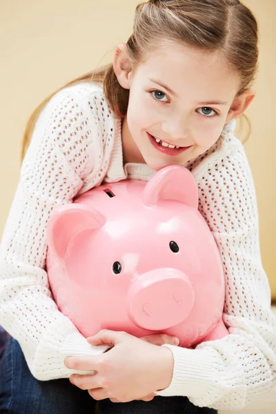 Siempre ahorro el dinero de mi bolsillo. Retrato recortado de una linda niña sonriendo mientras sostiene una hucha. —  Fotos de Stock