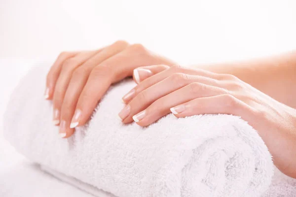 Unghie curate. Colpo ritagliato di mani di donne che si riposano su un asciugamano. — Foto Stock