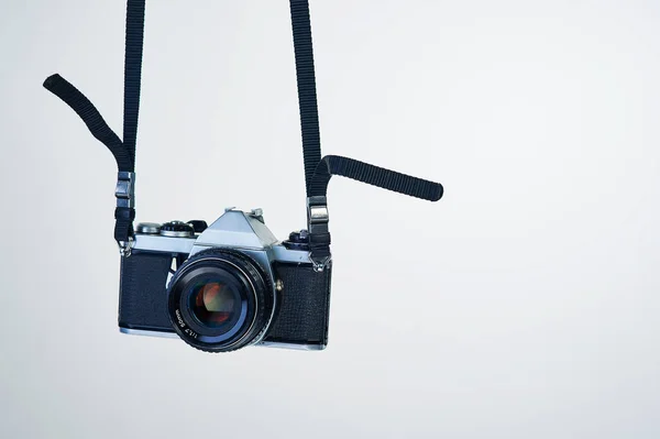 La fotografía cinematográfica regresa. Captura de estudio de una cámara colgando de su correa. — Foto de Stock