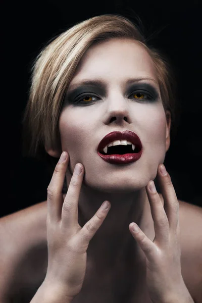 Stworzenie nocy. Uwodzicielska wampirzyca z czerwonymi ustami na ciemnym tle. — Zdjęcie stockowe