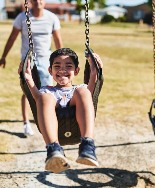 Quiero ir más alto. Retrato de un niño alegre balanceándose en un columpio afuera en un parque durante el día. —  Fotos de Stock
