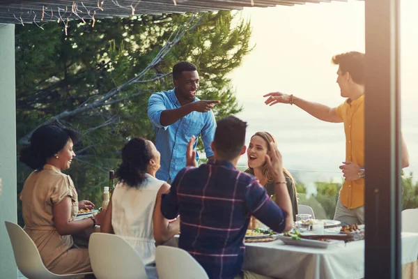 Tienes razón, amigo. Foto de un grupo de amigos disfrutando de una comida y bebidas juntos alrededor de una mesa en una reunión al aire libre. — Foto de Stock