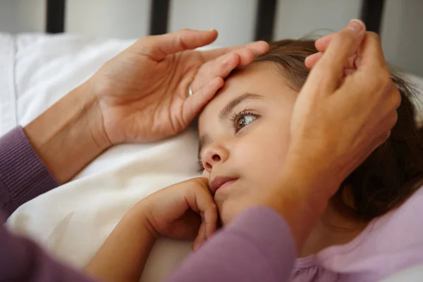 Ho sicuramente la sua attenzione ora.... Girato di una madre premurosa che sente la fronte della sua bambina malata. — Foto Stock