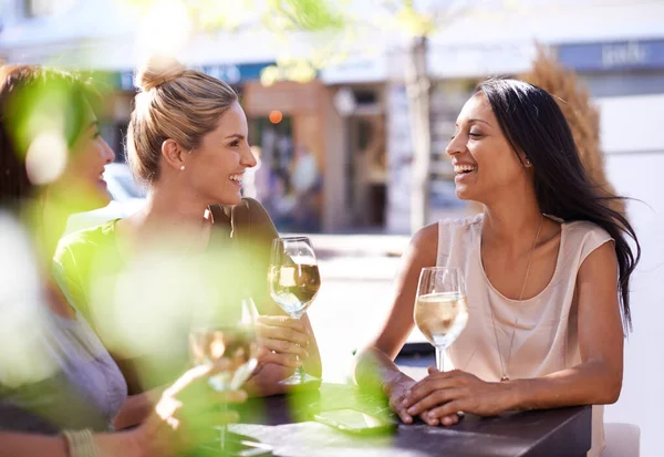 Трохи винного знавця. Обрізаний знімок трьох жінок, які насолоджуються келихом білого вина в тротуарному кафе . — стокове фото