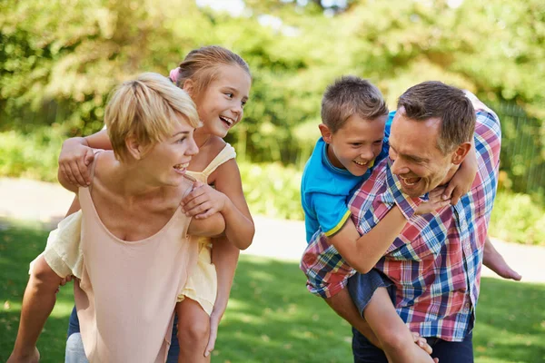 Whos going to win. Two parents having a race while carrying their young children on their backs. — Stock Photo, Image